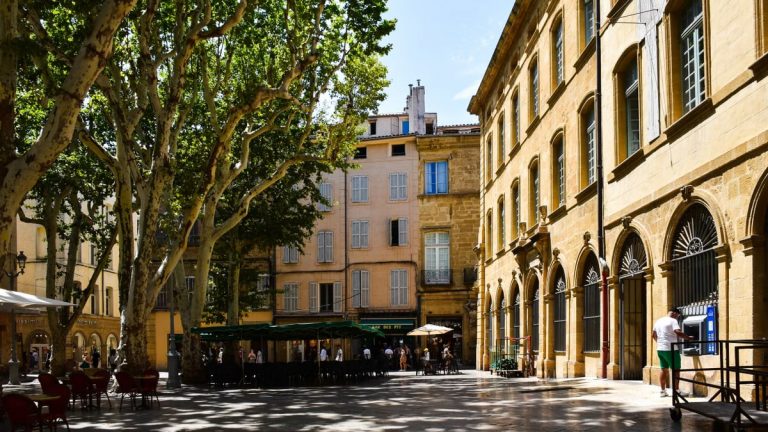 A sunny day in Aix-en-Provence showcasing historic architecture and lush trees.